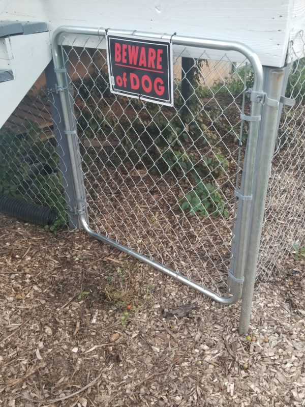 a gate with a warning sign for your dog kennel